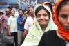 A smiling woman queuing up in front of a crowd in a country of South Asia